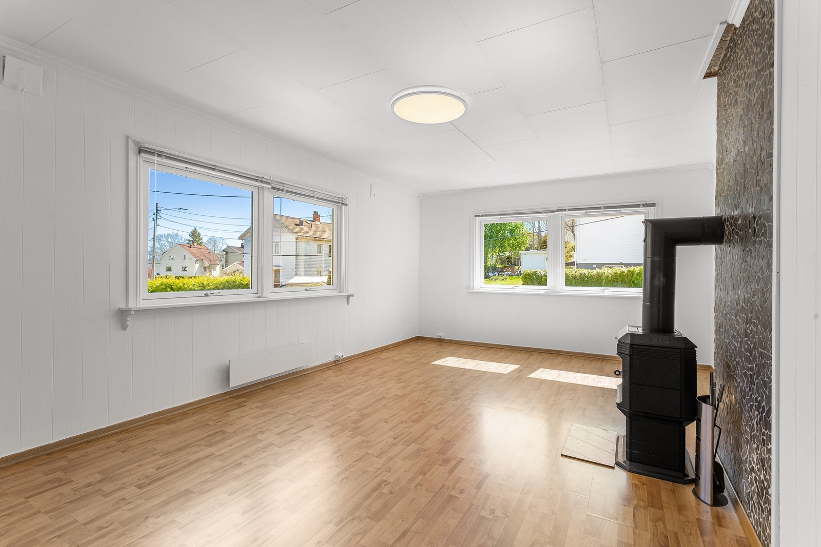 Stuen i første etasje er et lunt samlingspunkt med en vedovn for ekstra varme og hygge. Galleribilde
