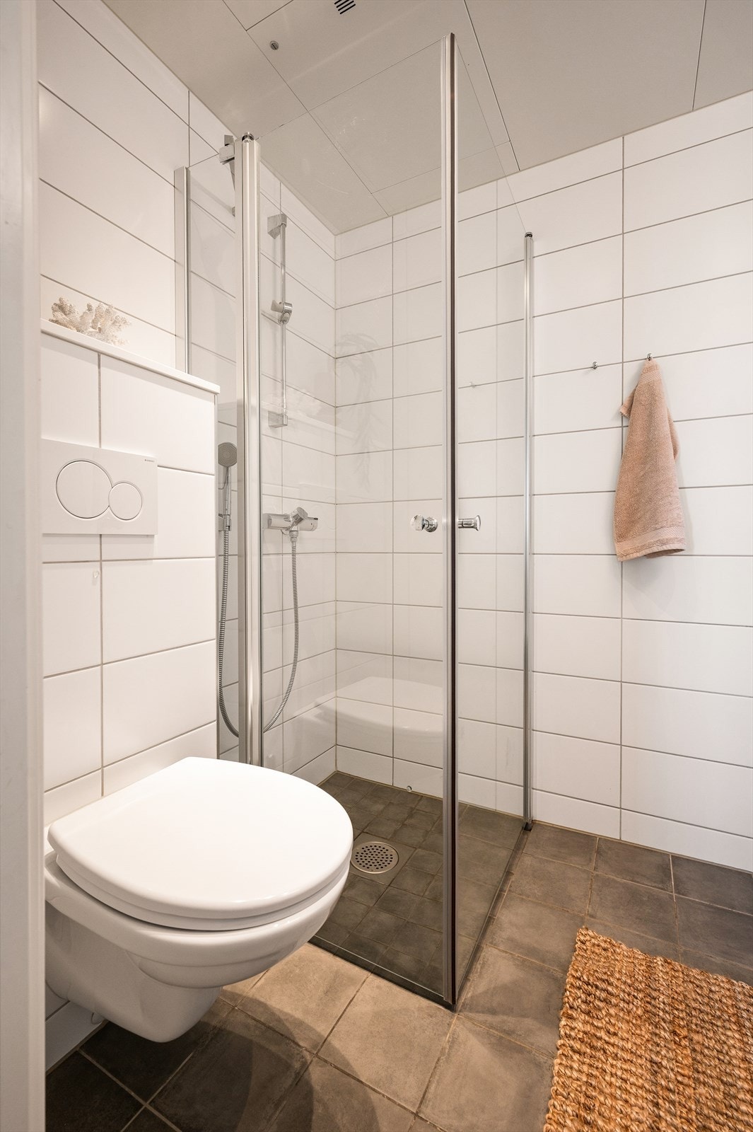 Flislagt gulv med vannbåren varme, flislagte vegger og innfelte downlights i himling. Galleribilde