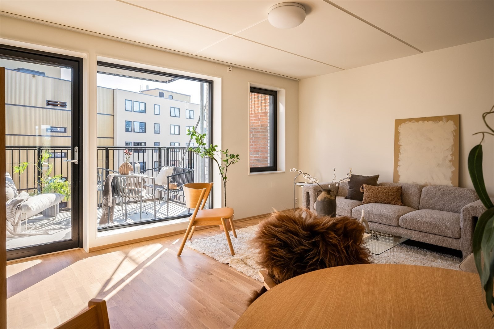 Stue med store vindusflater fra gulv til tak, som slipper inn rikelig med naturlig lys og gir en luftig romfølelse. Galleribilde
