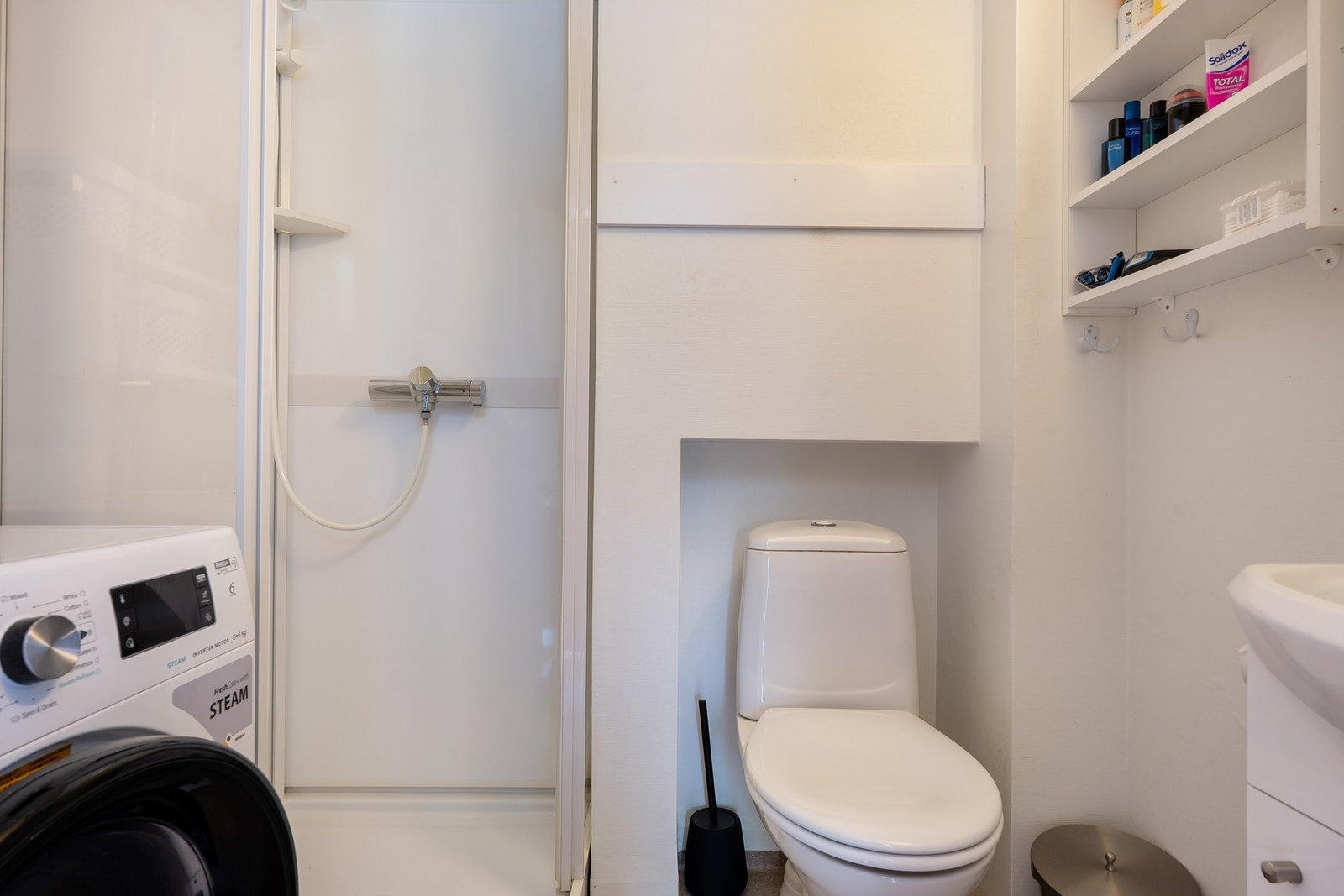 Bad i første etasje med dusjkabinett, toalett og servantinnredning. Galleribilde