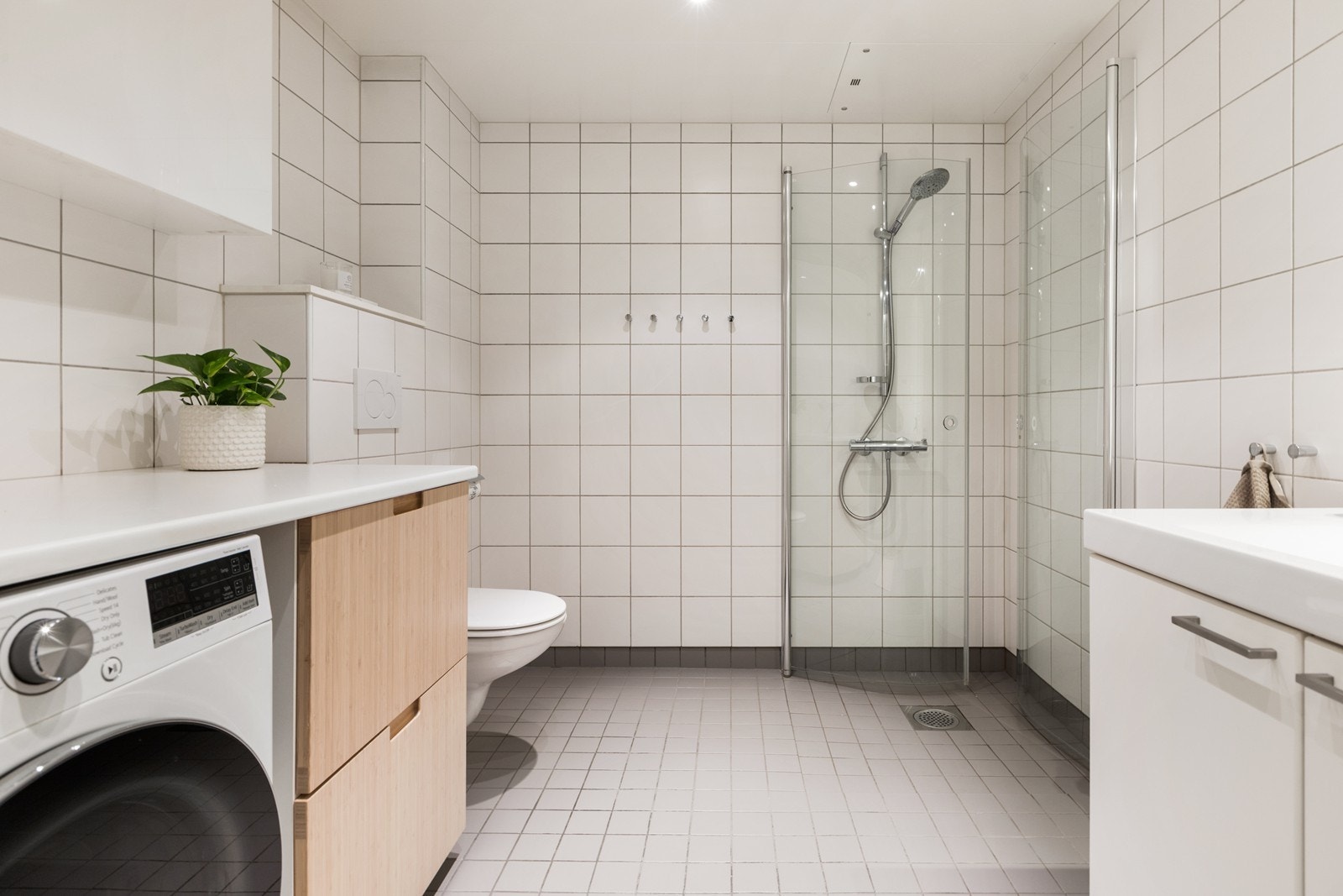Badet er en prefabrikkert våtromskabin med flislagte vegger og gulv. Elektriske varmekabler i gulv. Nedfelt servant, veggmontert toalett og dusjhjørne, samt opplegg for vaskemaskin. Galleribilde