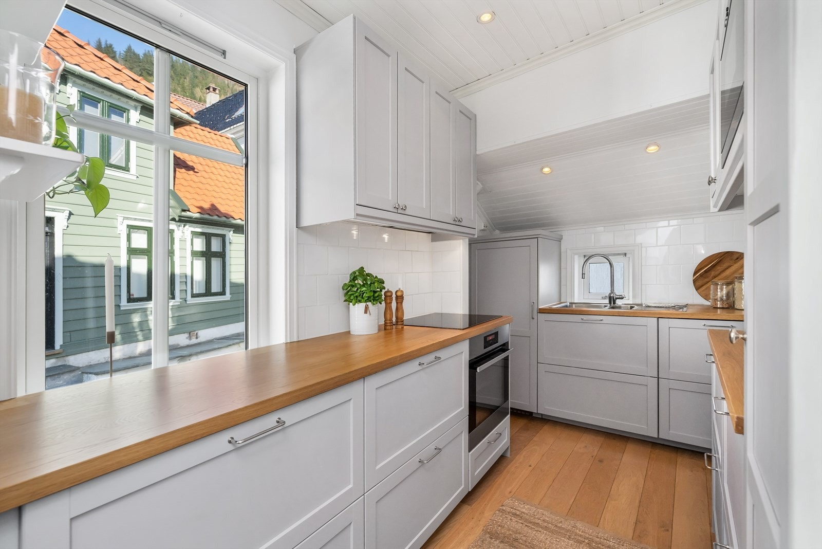 Kjøkkeninnredningen har profilerte fronter og det er laminat benkeplate med finért finish og nedfelt vask. Galleribilde