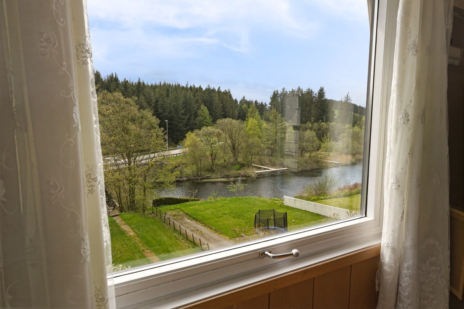Fra vinduene i stuen ser man rett ned på egen tomt og elven. Galleribilde