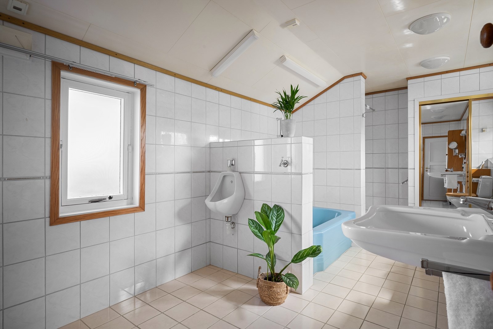 Badet er utstyrt med både badekar og dusjhjørne, og har elektriske varmekabler i det flislagte gulvet. Galleribilde