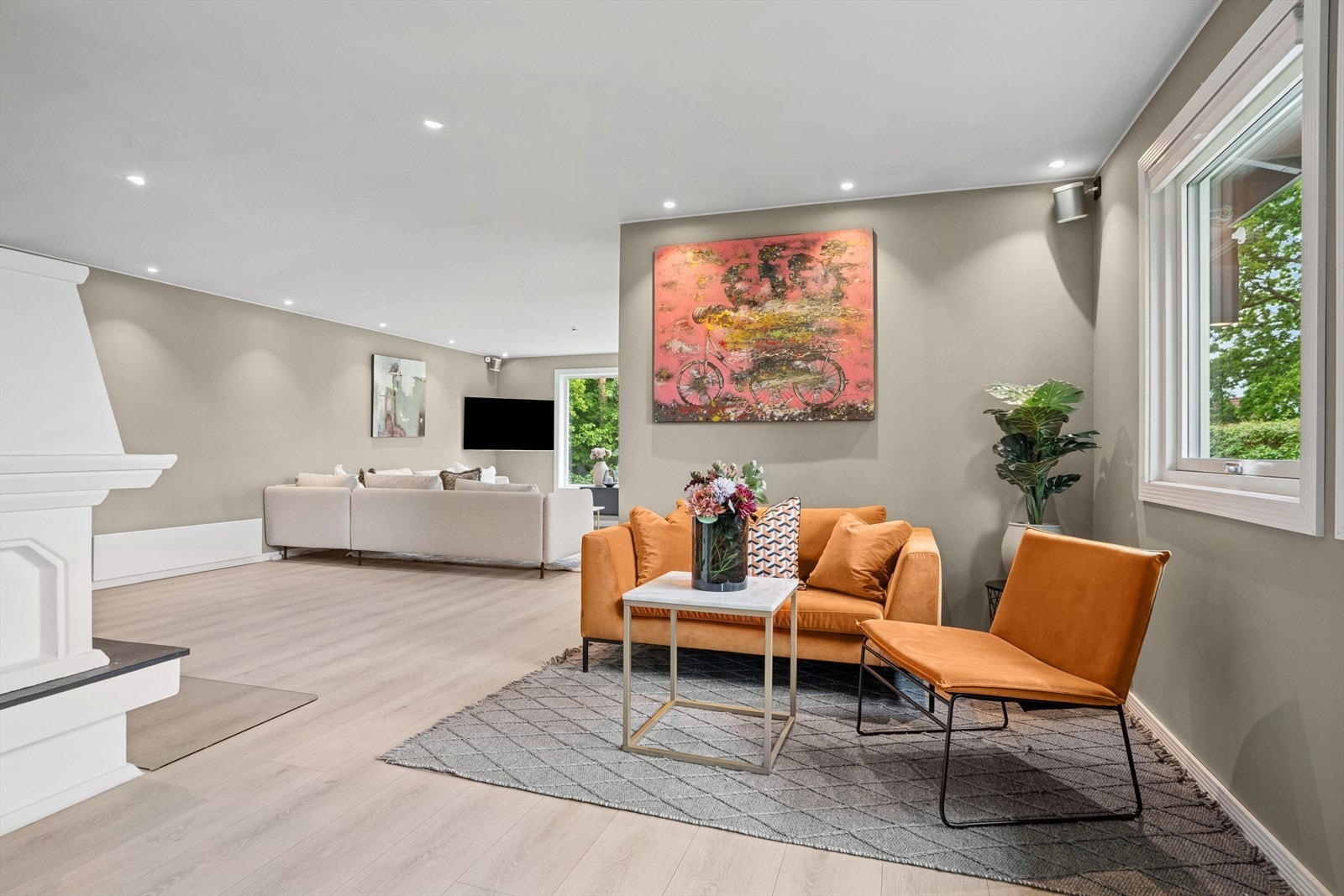 Stuen har malte vegger i en dus beigefarge, komplimentert med hvite lister og hvit himling med downlightsbelysning, som passer perfekt til boligens stil. Galleribilde
