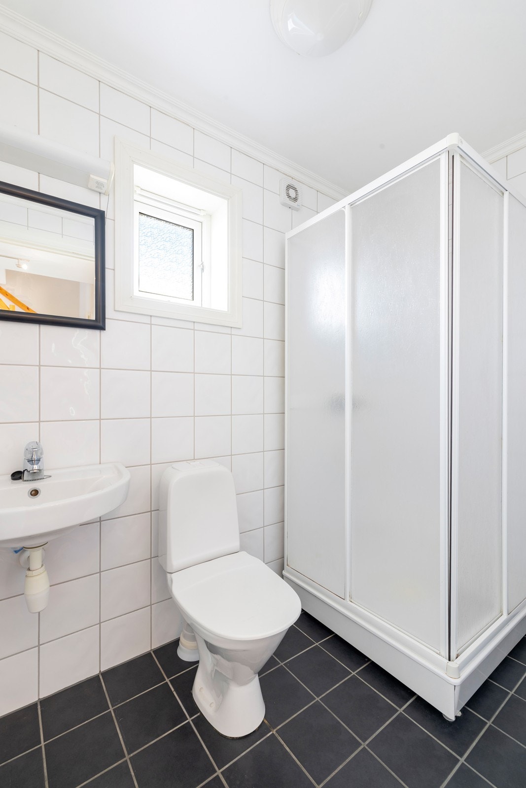Badet har dusjkabinett, servant og toalett. Galleribilde