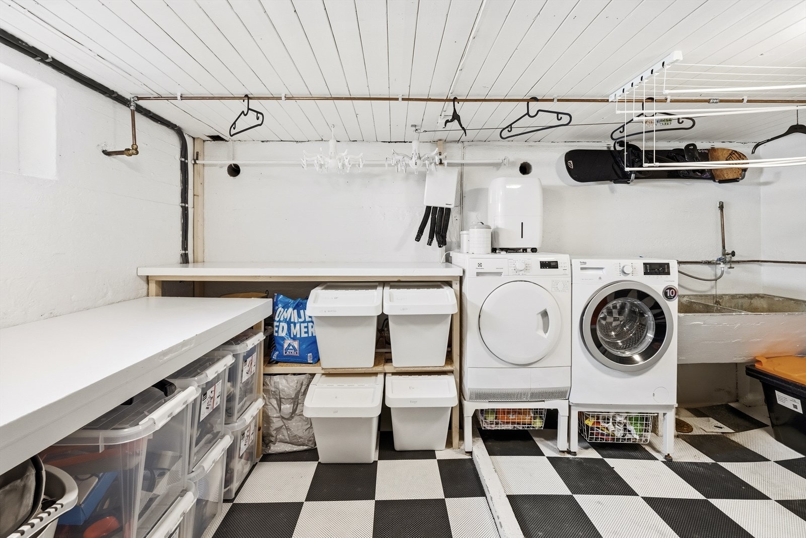 Vaskerommet har betonggulv, samt utslagsvask og opplegg for vaskemaskin og tørketrommel. Galleribilde