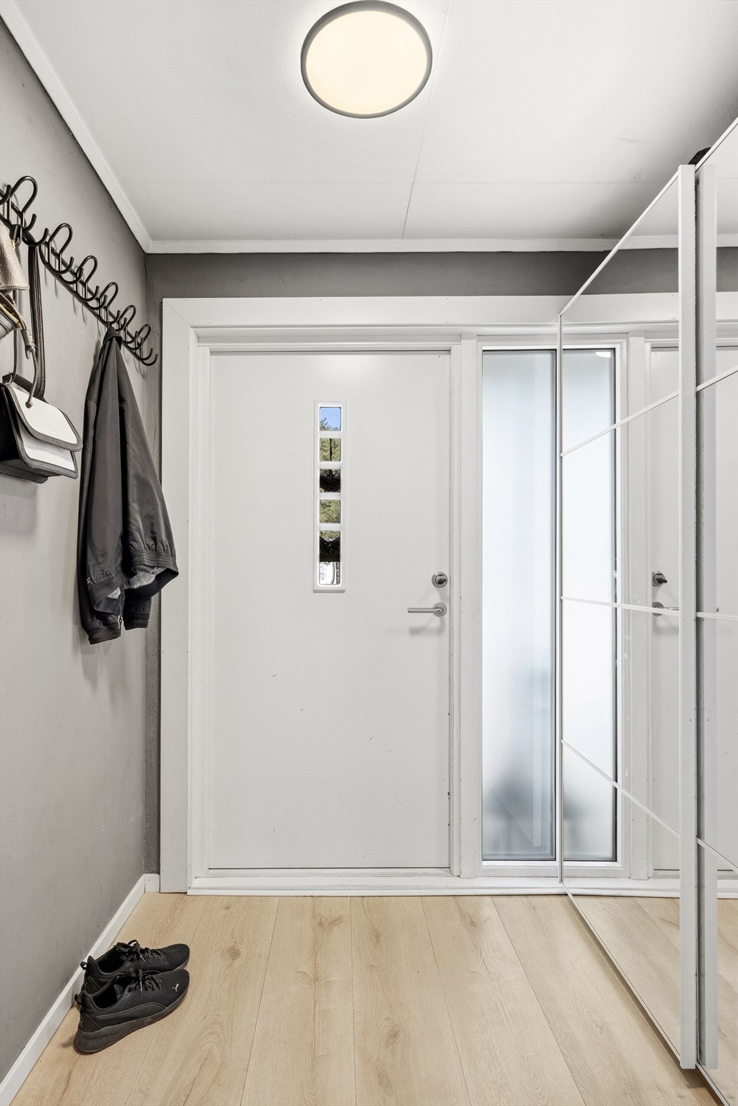 Praktisk og innbydende entré med gode oppbevaringsmuligheter til yttertøy og sko i skyvedørsgarderobe. Det er varme i gulvet på kjøkken og i yttergang. Galleribilde