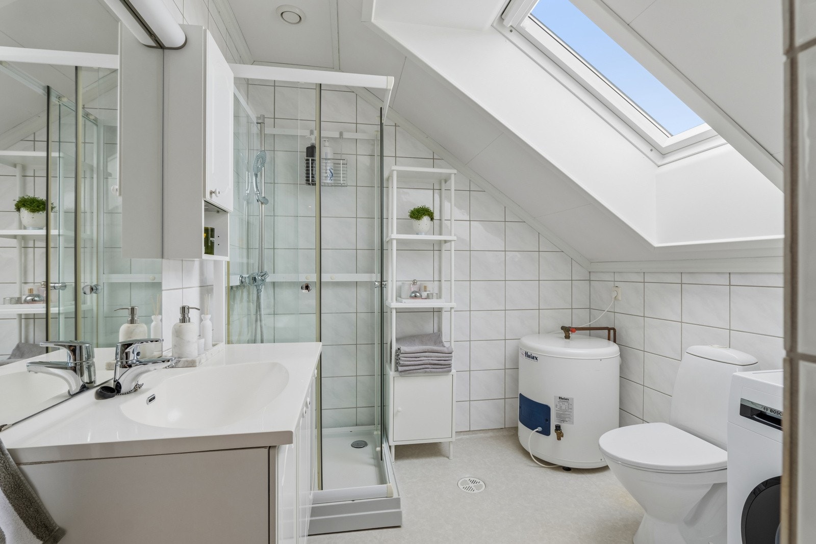 Romslig bad med innrednng, dusjkabinett, wc og opplegg for vaskemaskin Galleribilde