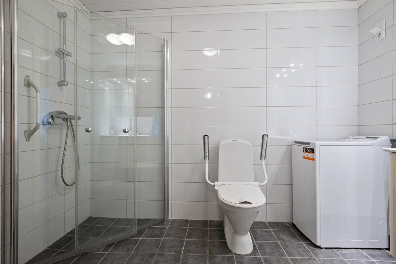 Flislagt bad med gulvvarme og praktisk opplegg for vaskemaskin. Galleribilde