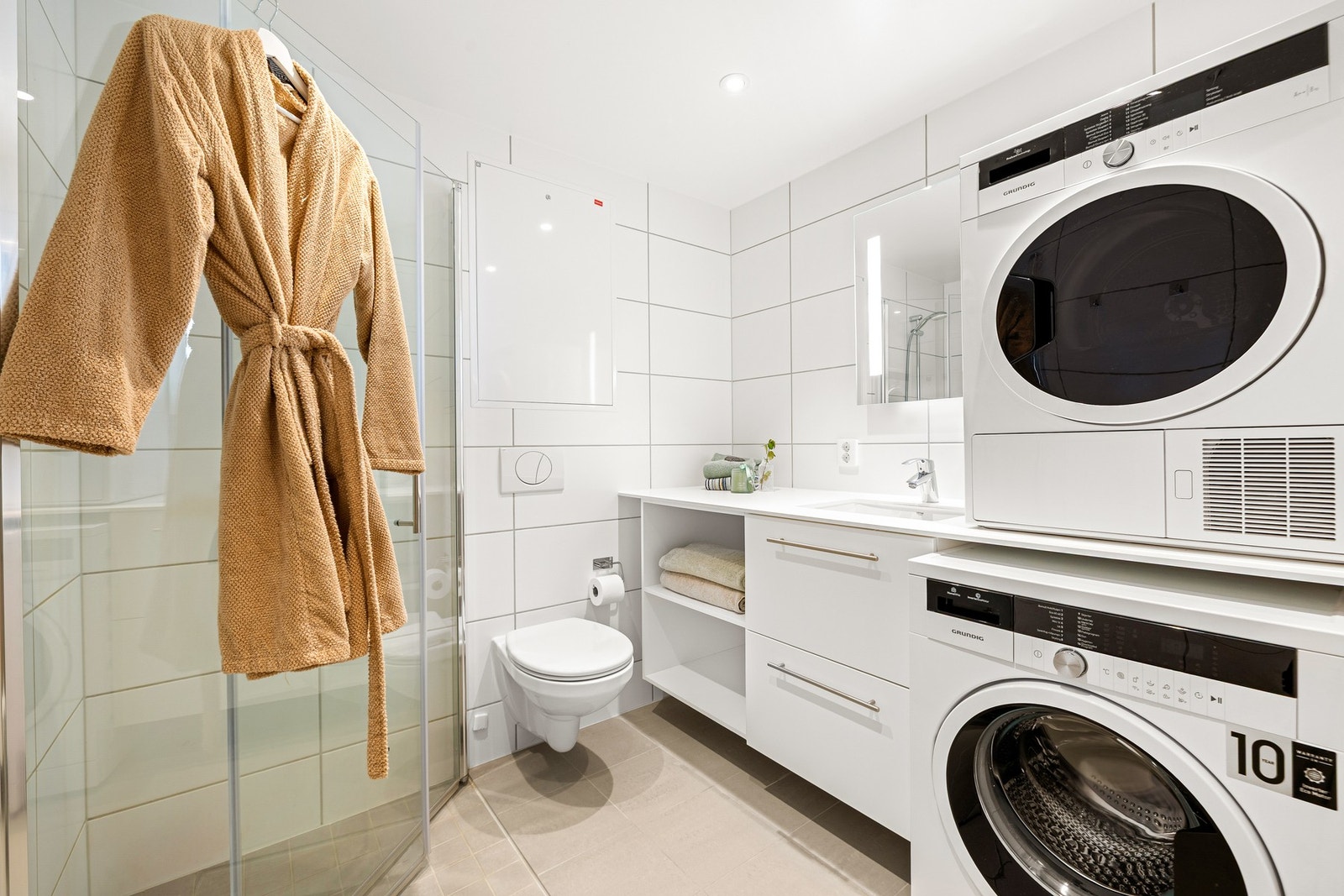 Leilighetens baderom oppleves pent og lyst med fliser på gulv og vegger. Badet varmes opp ved bruk av elektriske varmekabler i gulv. Galleribilde