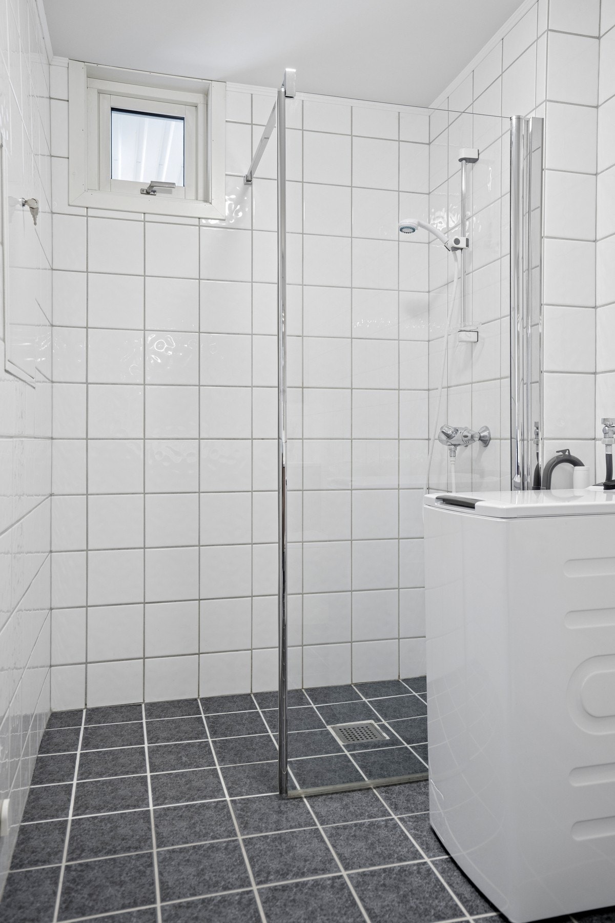 Badet har dusjhjørne med innfellbare glassdører og opplegg for vaskemaskin. Galleribilde