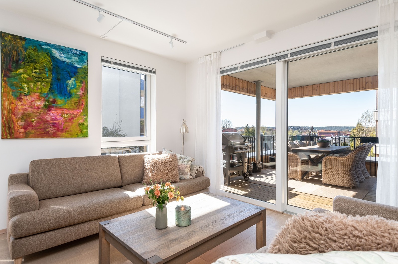 Stue med stor skyvedør til en romslig overbygget balkong mot vest. Galleribilde