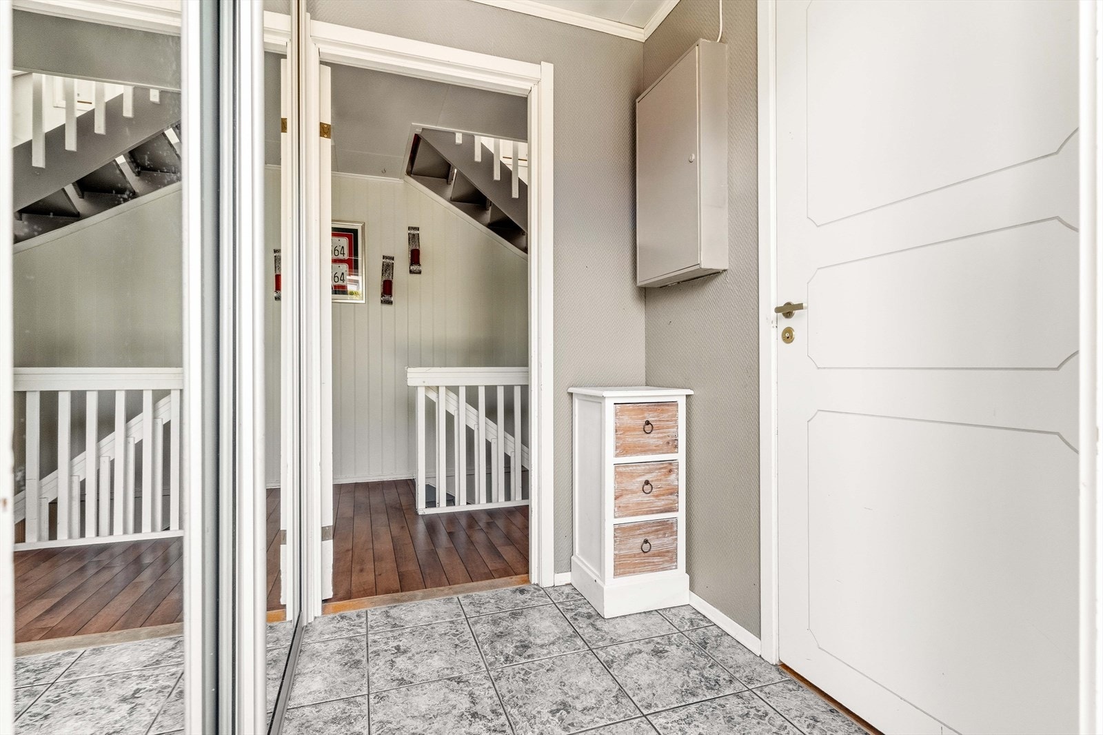 Entréen har flislagt gulv med gulvvarme. Her er det plass for skyvedørsgarderobe og kommode for oppbevaring. Galleribilde