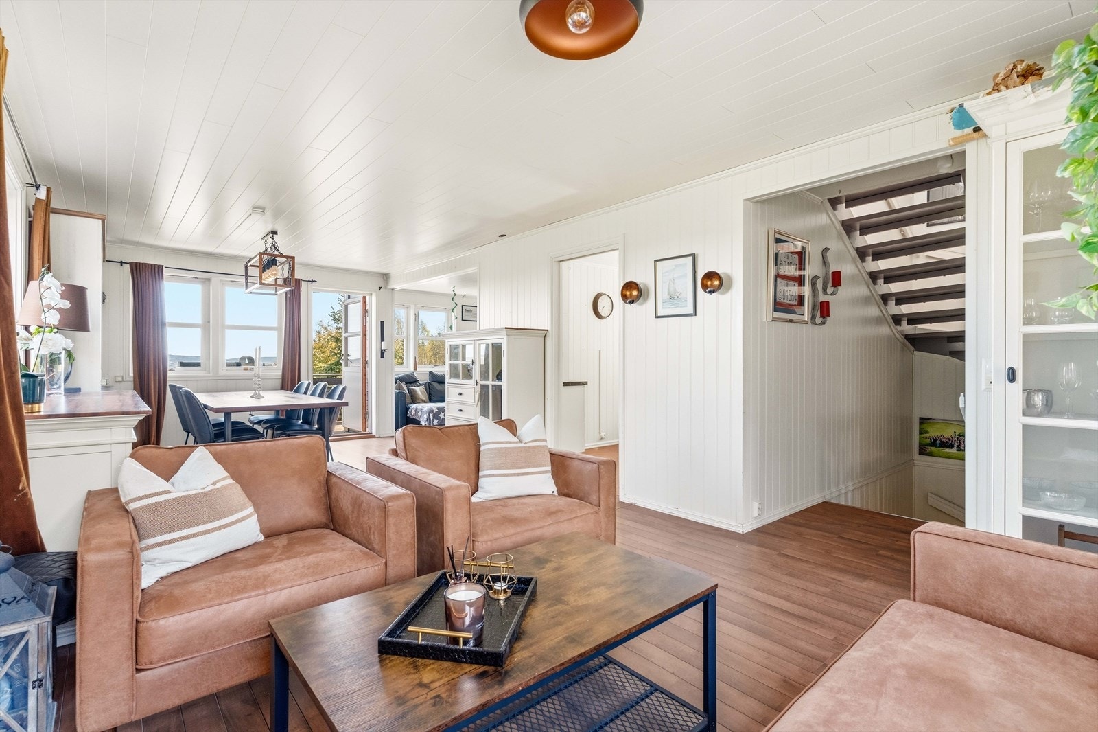 Stuen er lys og romslig med plass til både sofagruppe og en stor spisestue. Galleribilde
