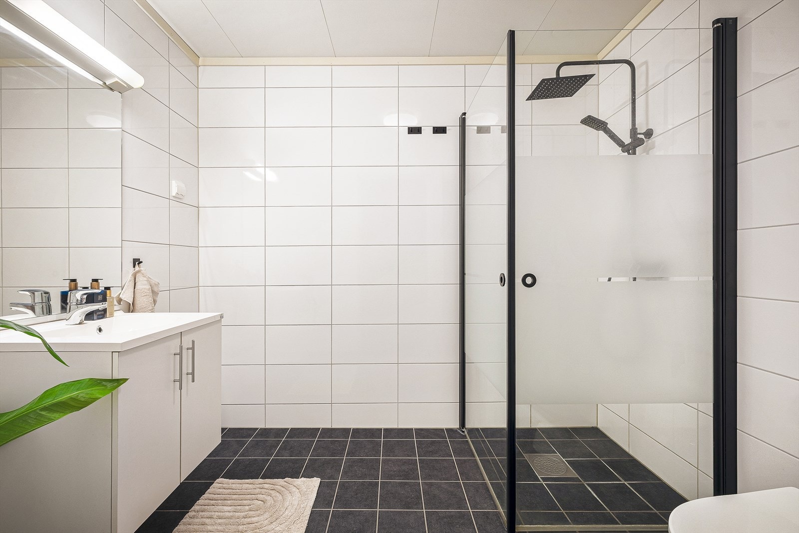 Helfliset badet med servant, toalett og dusjvegger/hjørne. Galleribilde