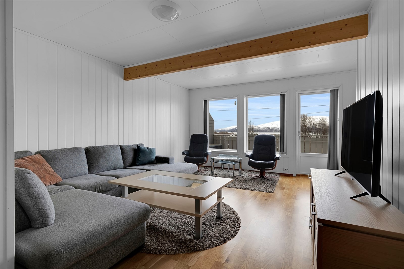 Innbydende stue med rikelig naturlig lysinnslipp fra store vindusflater. Galleribilde