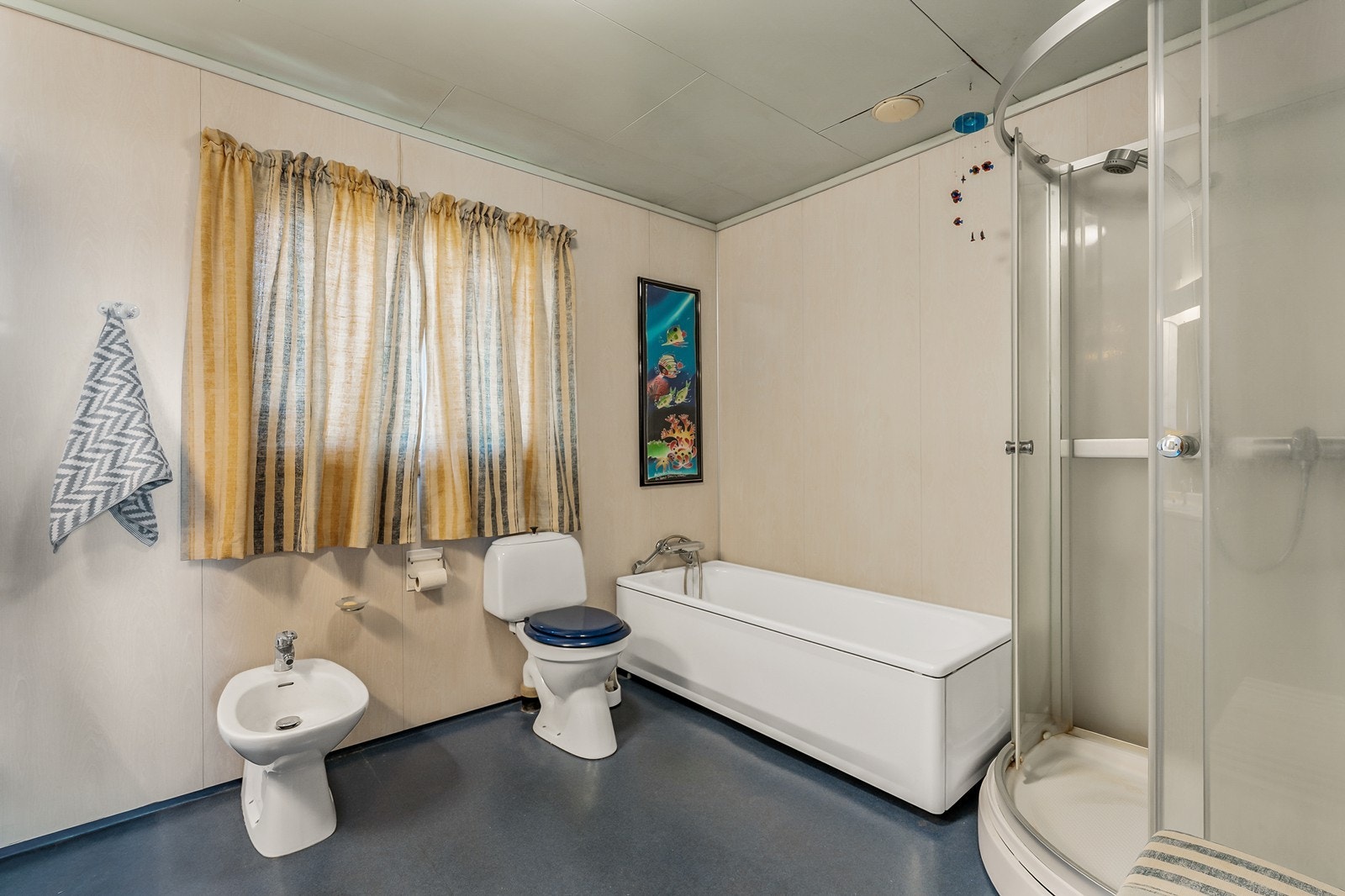 Rommet har et badekar, bidet, dusjkabinett og baderomsinnredning med vask. Galleribilde