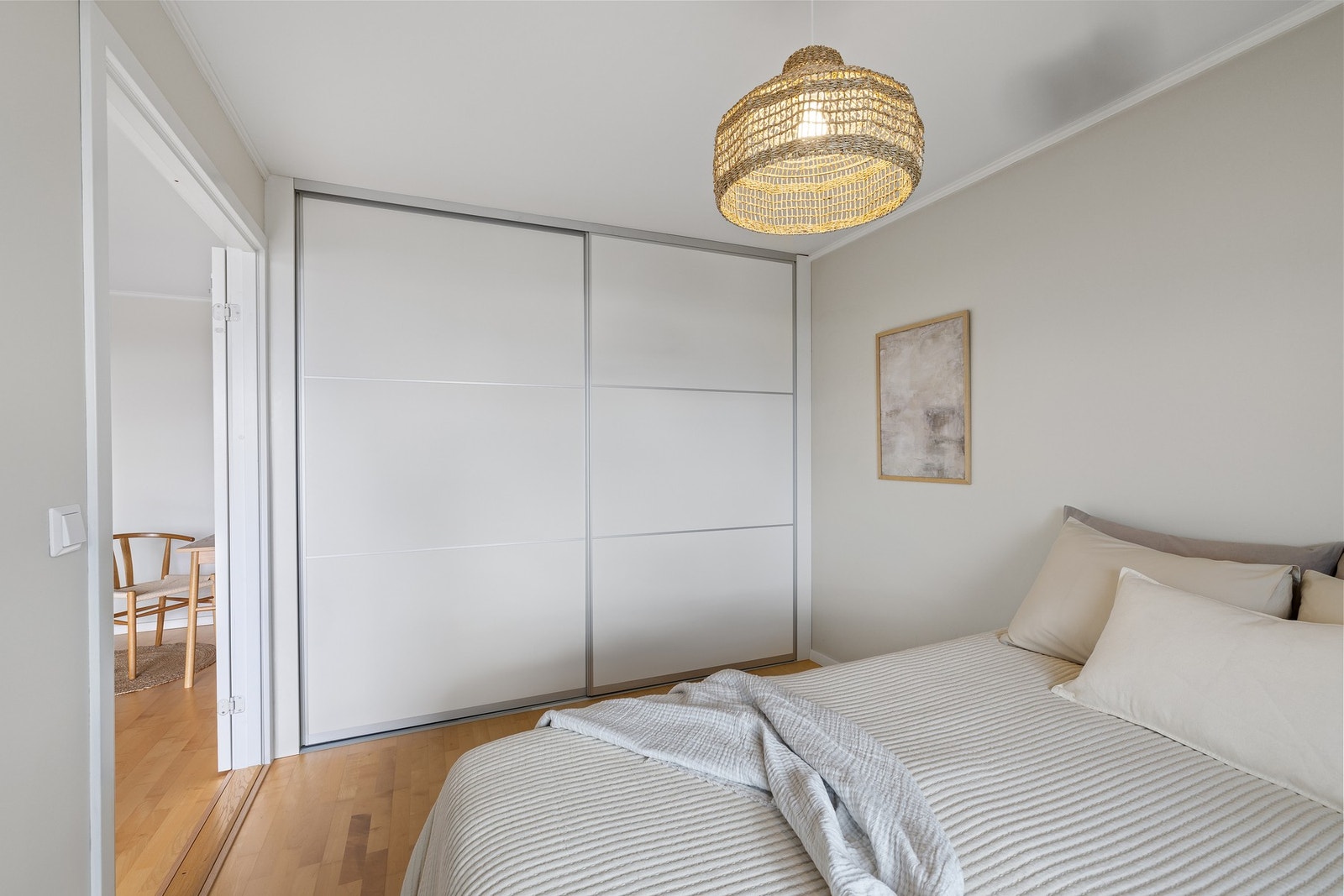 Hovedsoverom er innredet med en romslig skyvedørsgarderobe med glatte hvite fronter Galleribilde