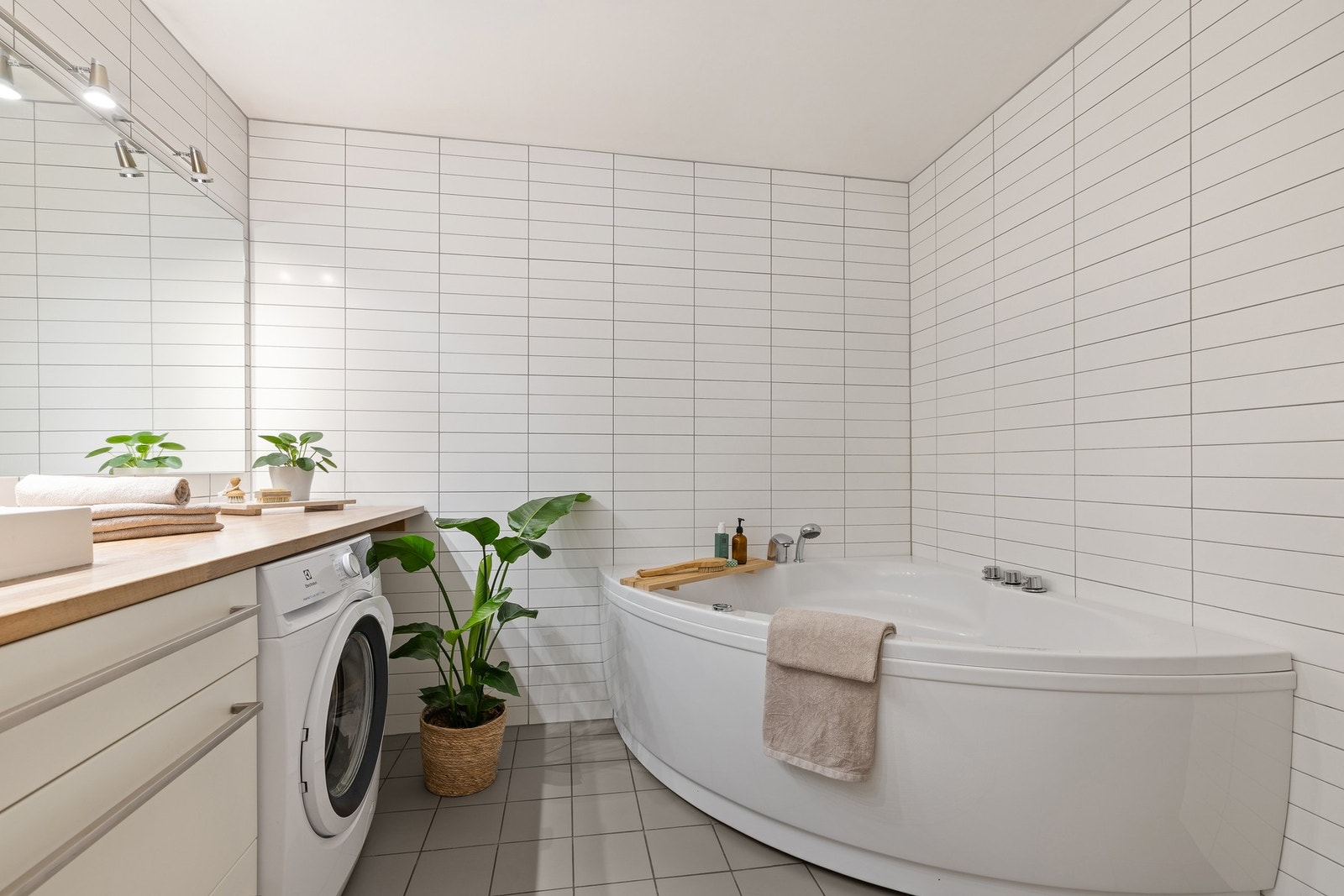 Det romslige badet har plass for et stort badekar og doble servanter med skuffeseksjoner Galleribilde