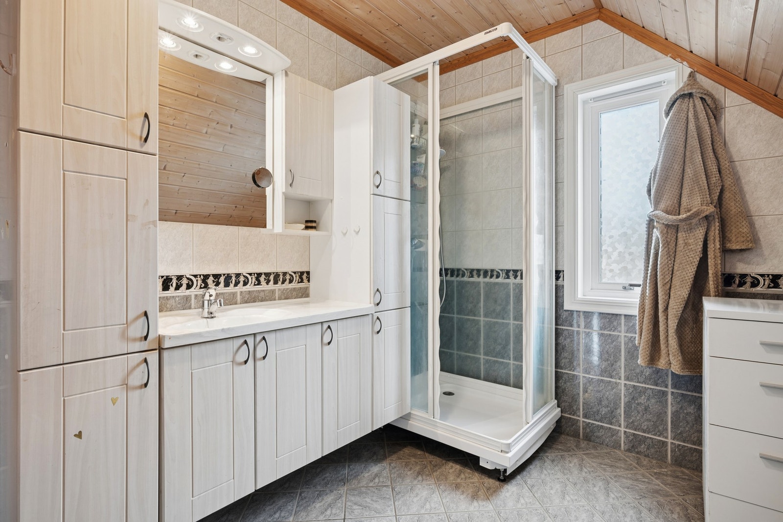 Det har romslig innredning med side- og underskap, dusjkabinett og wc. Galleribilde