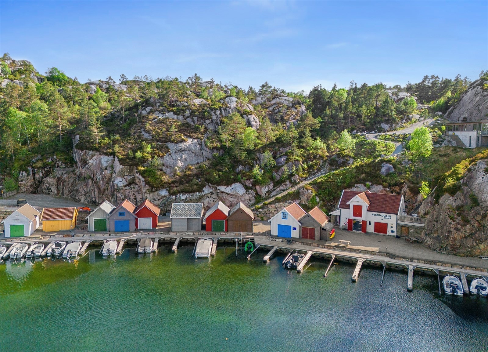 Vesthaugane Bryggje består av 10 stk. fargerike naust med felles wc/bad for nausteierene i næringsbygget. Galleribilde