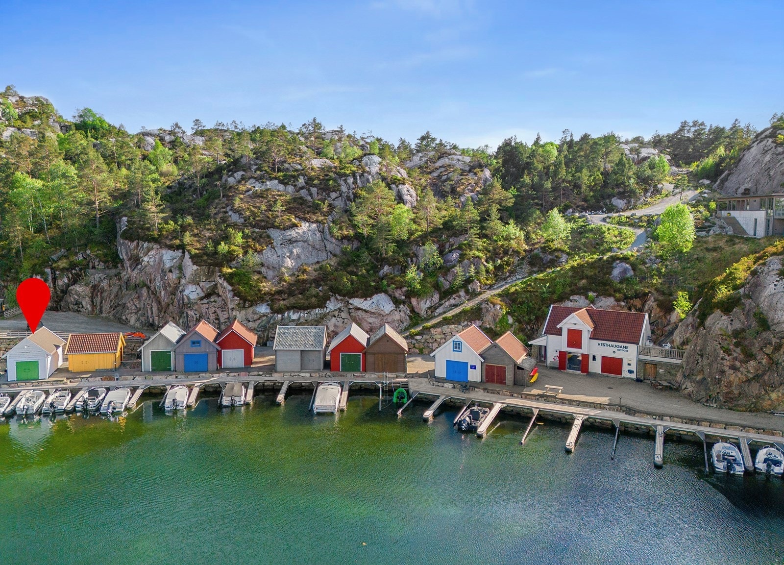 Vesthaugane Bryggje består av 10 stk. fargerike naust med felles wc/bad for nausteierene i næringsbygget. Galleribilde