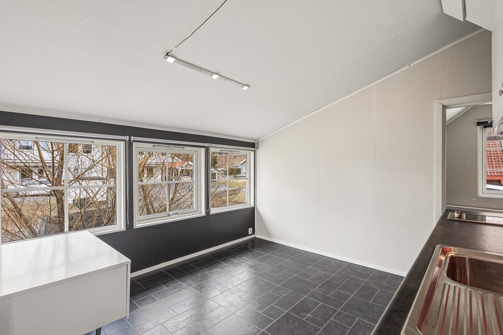 Stuedelen har plass til en liten sittegruppe og får lys fra tre vinduer. Galleribilde