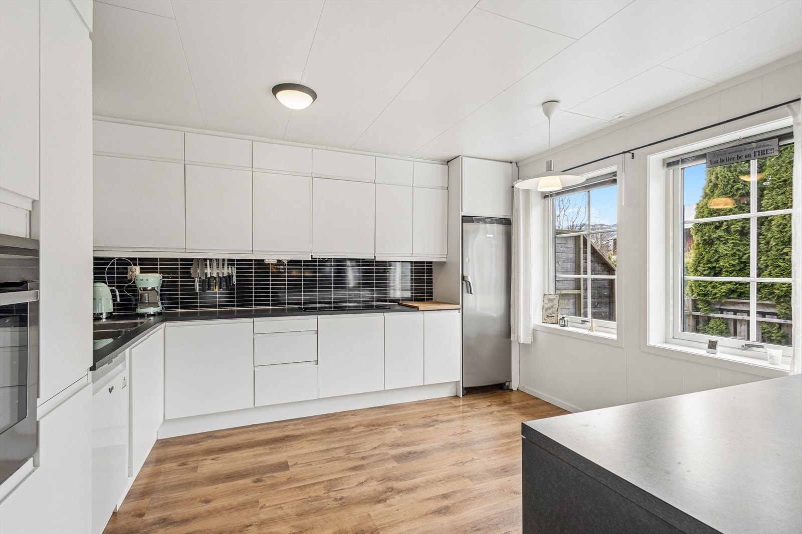 Hvitevarer som komfyr og koketopp er integrert i innredningen, samt at det er plass til frittstående oppvaskmaskin og kjøleskap. Galleribilde