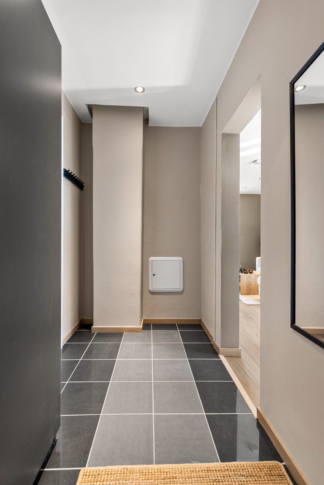 Fra entréen er det åpen tilgang videre inn i stuen og til badet. Leiligheten har en smarthusløsning for styring av varme. Galleribilde