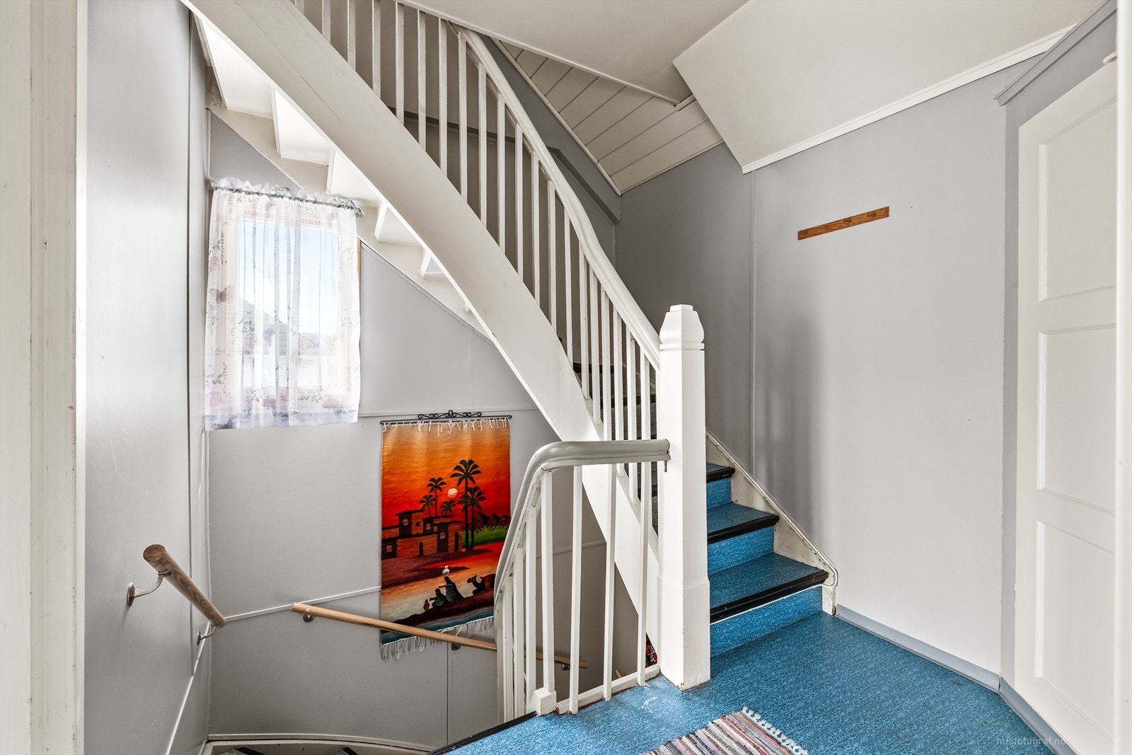 Malt tretrapp med håndløper leder opp til andre etasje. Galleribilde