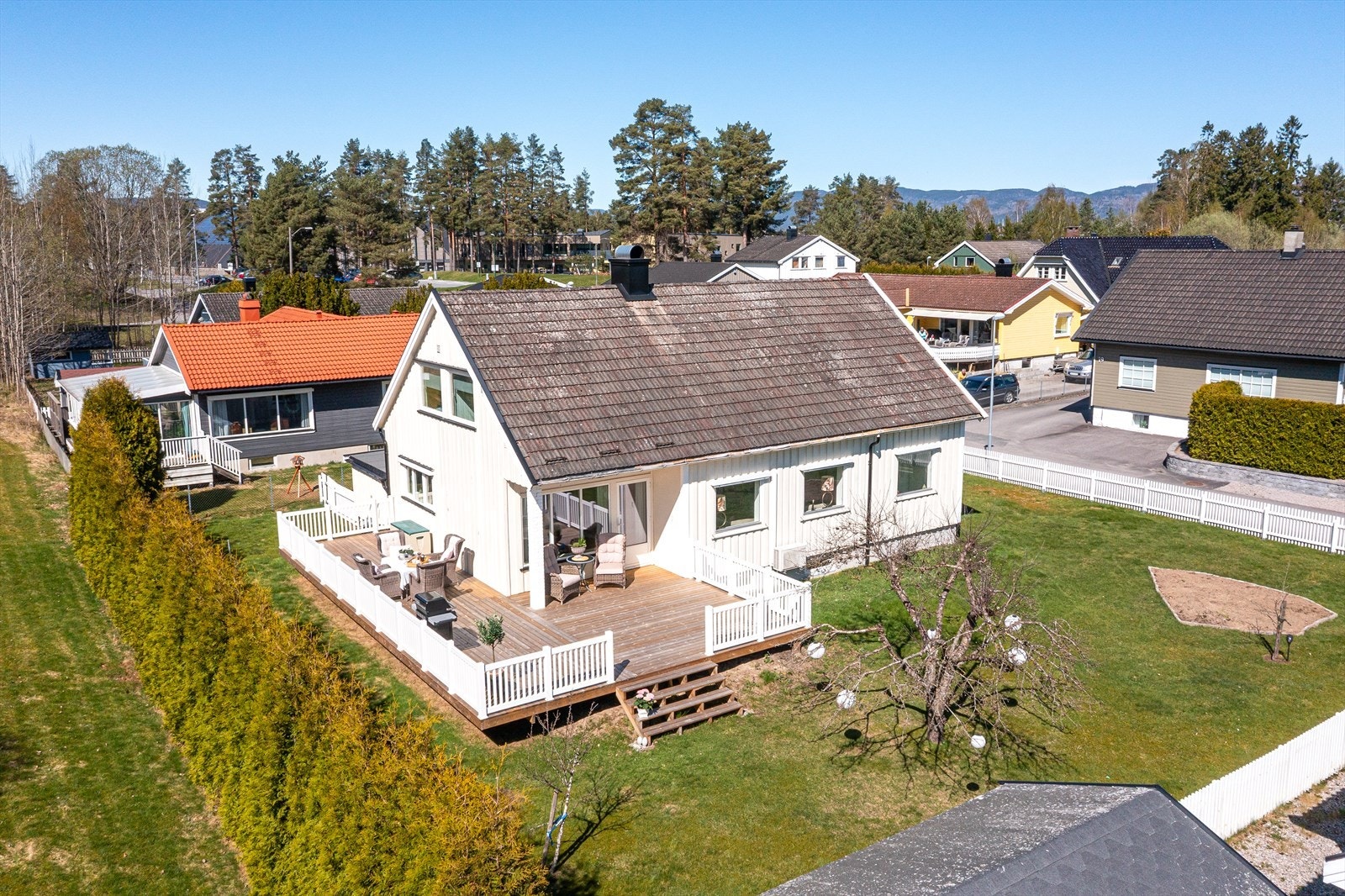 Eiendommen har en pent opparbeidet hage med plen og beplantning. Galleribilde
