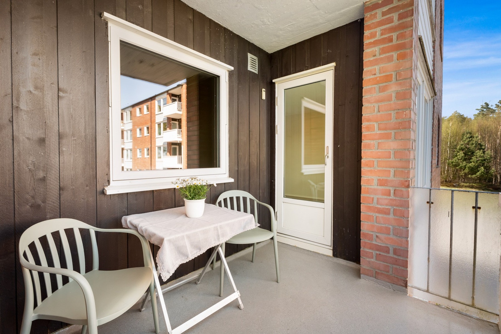 Balkongen har malt betongdekke, tett rekkverk med frostet glass på sidene og fin plass til utemøbler. Galleribilde