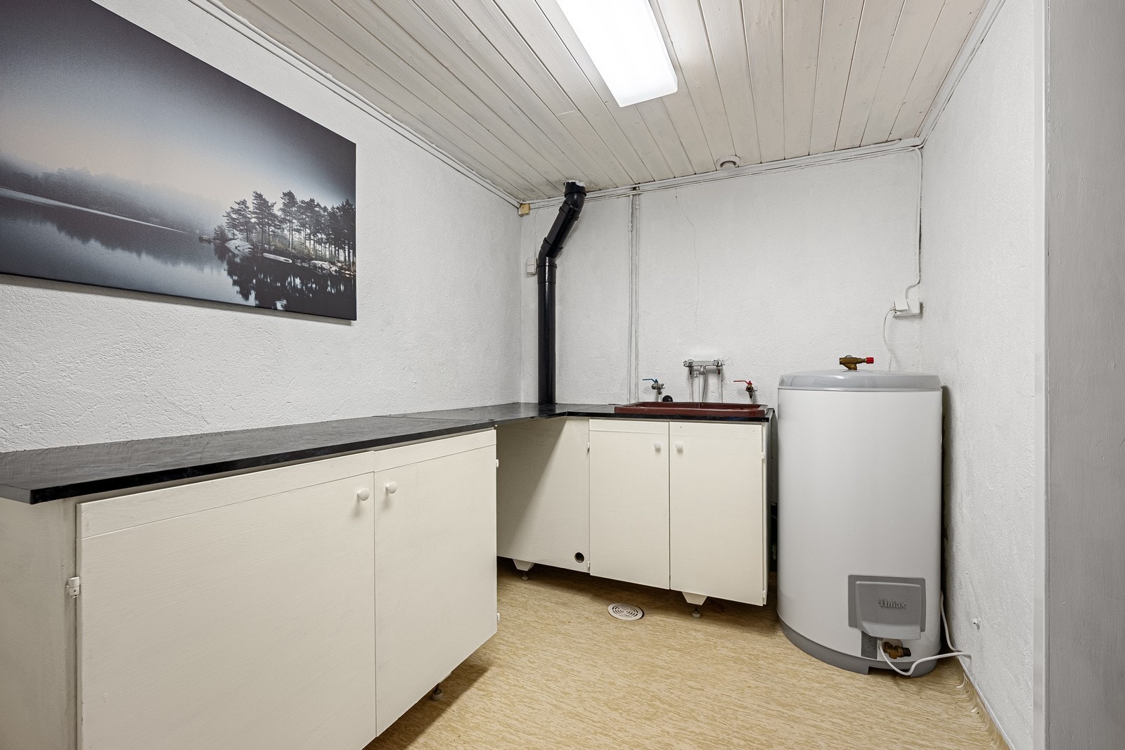 Vaskerommet inneholder opplegg for vaskemaskin, vaskekum, skap og ny varmtvannsbereder. Galleribilde