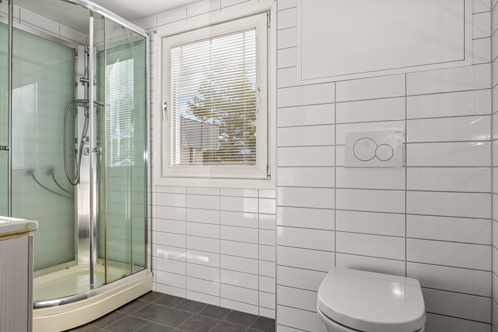 Badet er utstyrt med vegghengt toalett og dusjkabinett. Opprinnelig separat bad og WC er slått sammen til et romslig bad. Galleribilde