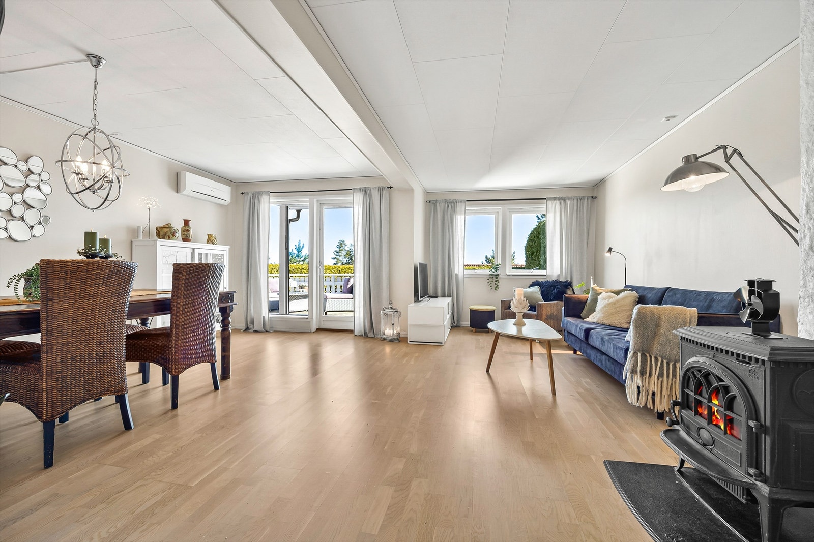 Stuen har parkett på gulv, peisovn for kalde dager og en luft-til-luft varmepumpe fra 2012. Galleribilde
