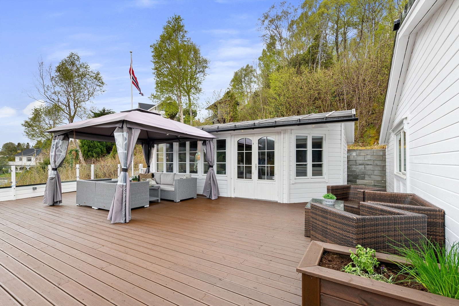 Uteområdet inkluderer en romslig terrasse og en tilhørende utestue. Galleribilde