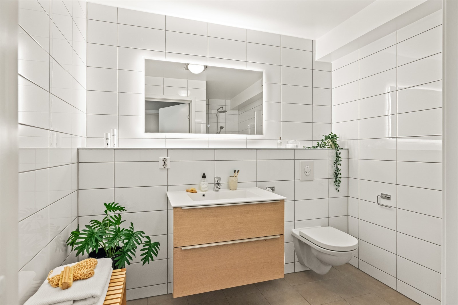 Badet i underetasjen er flislagt og har servantseksjon med skuffer og speil med integrert belysning. Galleribilde