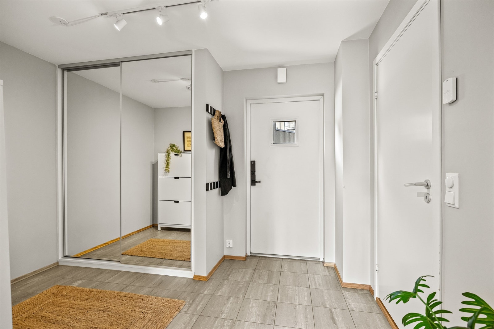 Entréen har flislagt gulv og en romslig skyvedørsgarderobe med speilfronter. Galleribilde