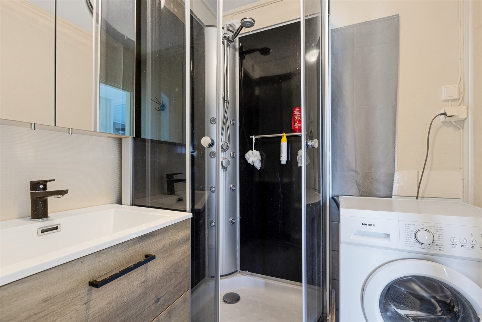 Badet er utstyrt med en skuffeseksjon med servant og speilskap over- dusjkabinett og toalett- samt opplegg til vaskemaskin Galleribilde