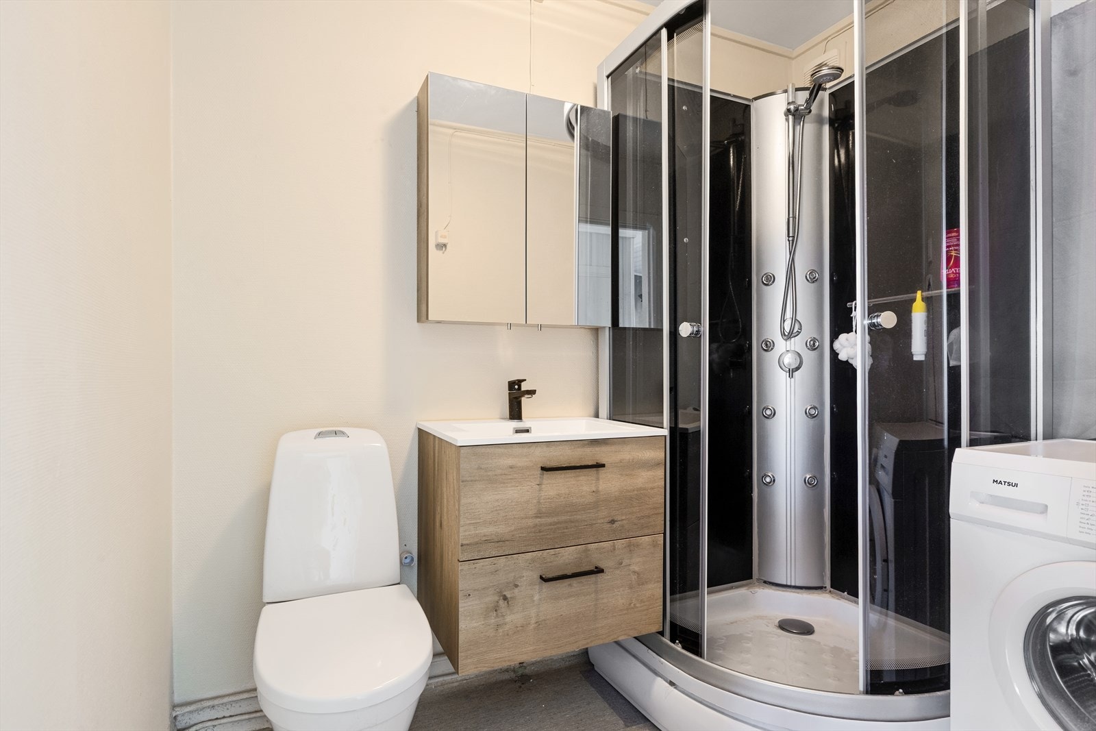 Badet har belegg på gulv og malt tapet på vegg Galleribilde