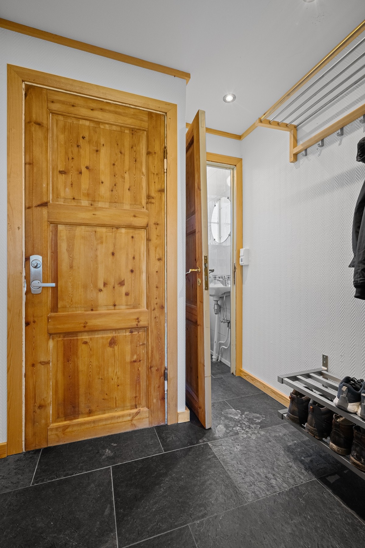 Entré med et lite gjestetoalett innenfor. Fra entré er det også en bakgang med utgang og trapp videre ned i kjeller. Galleribilde