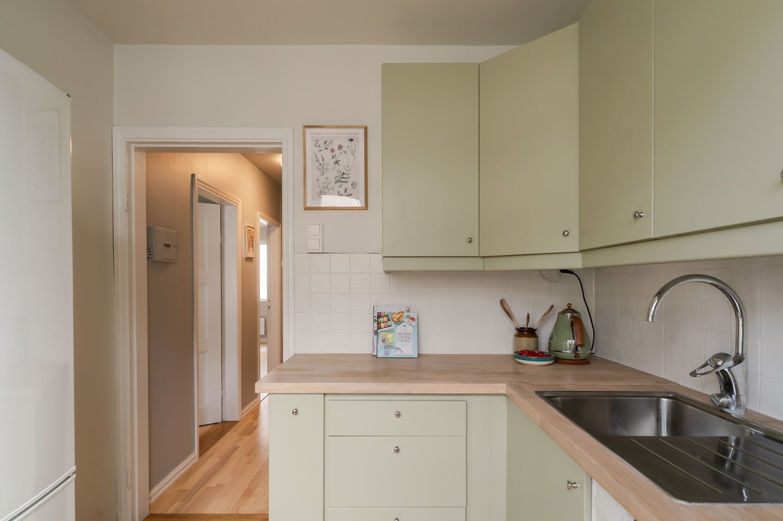 Kjøkkenet på 5,5 m² har en effektiv og funksjonell innredning med moderne fronter i en behagelig grønnfarge. Galleribilde