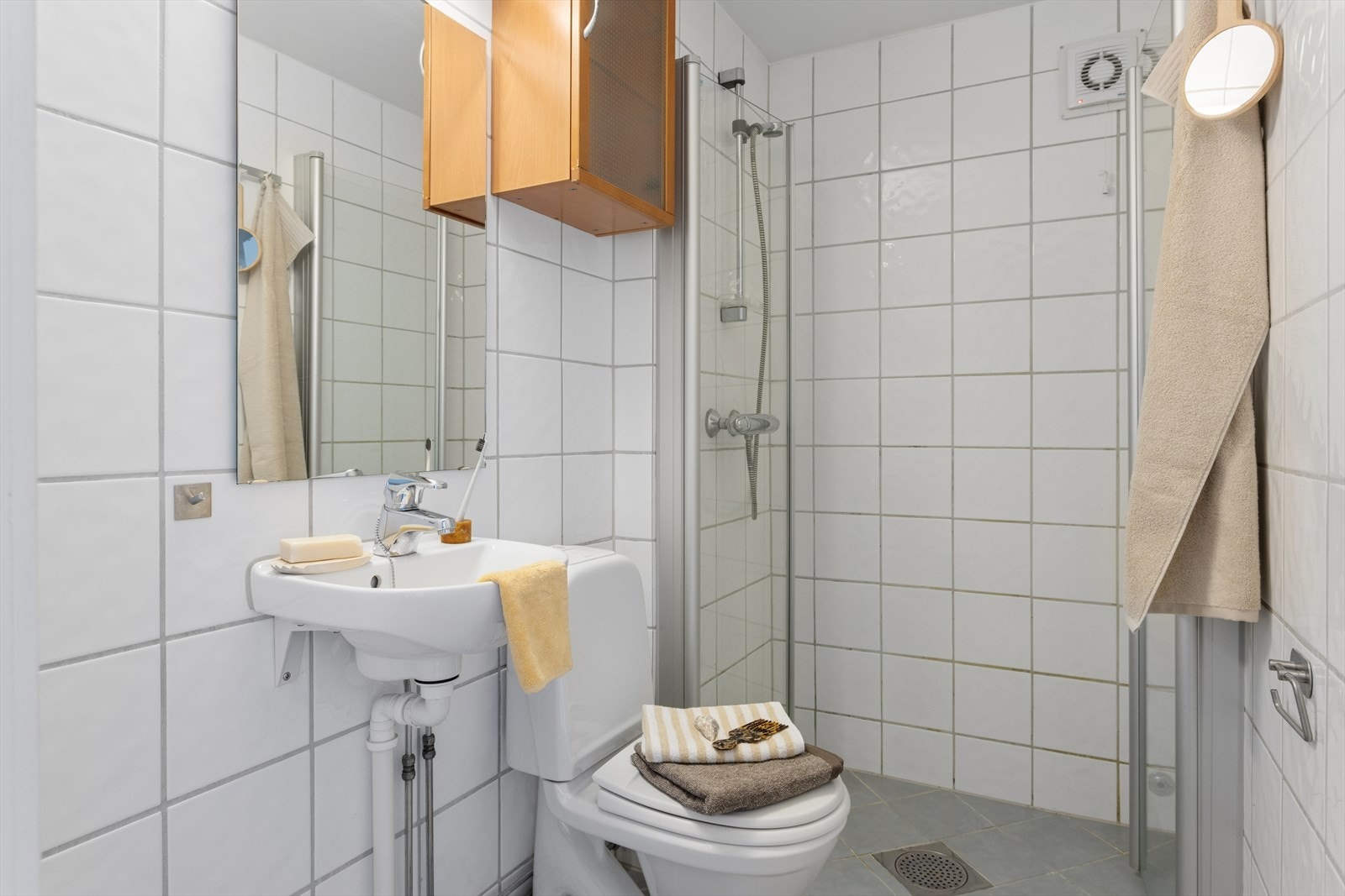 Flislagt bad med et nøytralt og tidløst uttrykk. Det er behagelig varme i gulv og fellesvaskeri i kjeller. Galleribilde