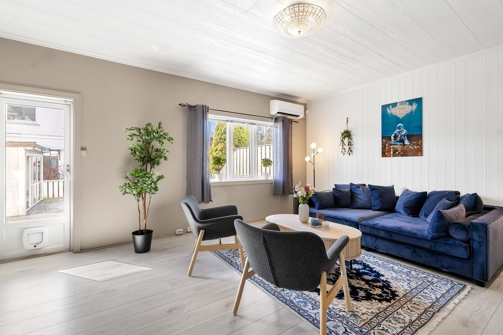 Romslig stue med plass til gode møbler - Det er både peis og varmepumpe som gir en god komfort Galleribilde