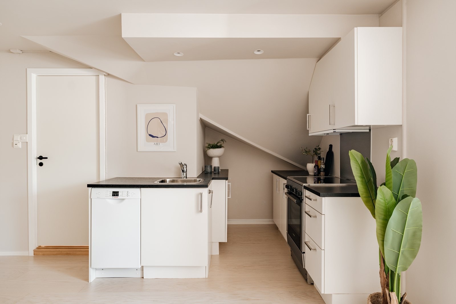 Leiligheten har et arealeffektivt og tidløst kjøkken. Kjøkkenet har innredning med hvite, glatte fronter og benkeplate i laminat. Galleribilde