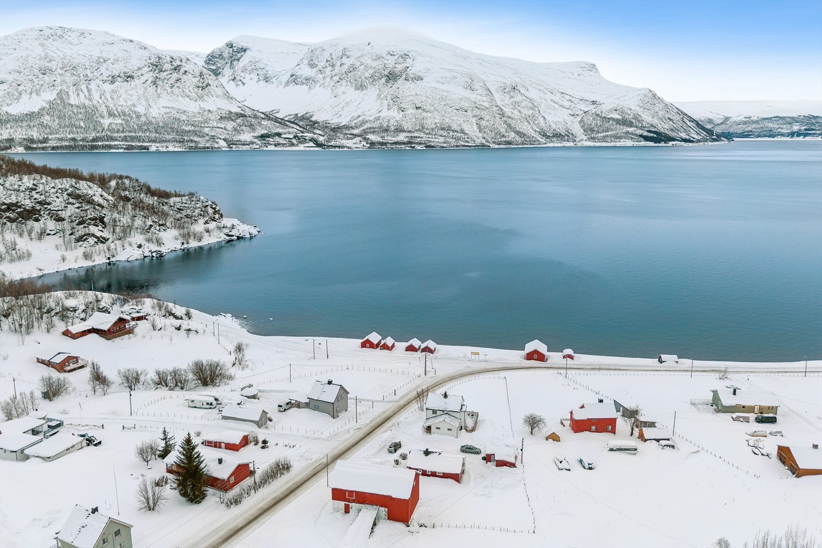 Eiendommen har en vakker beliggenhet ved Langfjorden, omgitt av høye fjell og storslått natur. Galleribilde