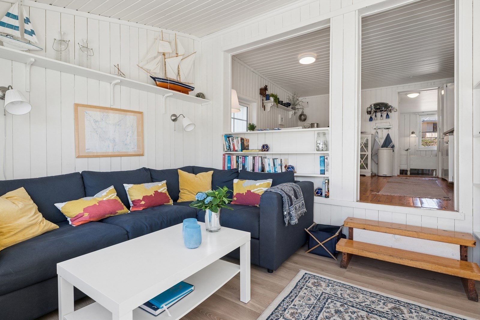 Stuen er et lunt rom med vegger i trepanel og laminat på gulvet. Galleribilde