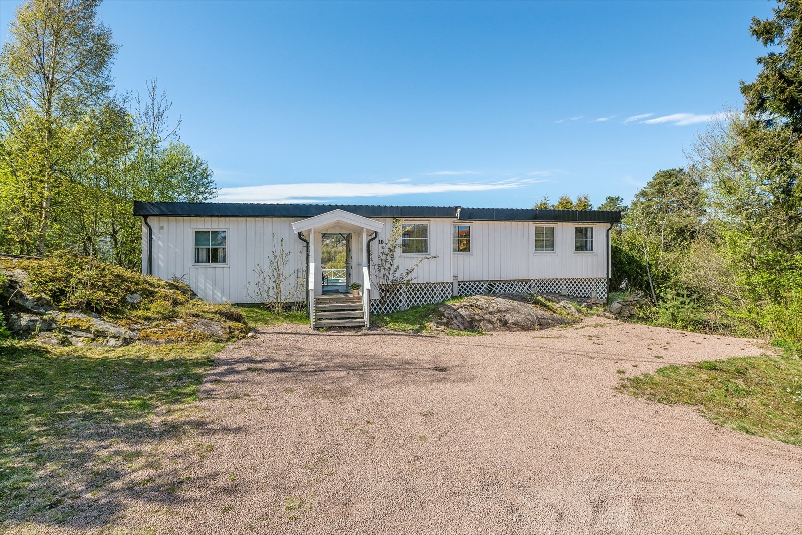 Eiendommen har en pent opparbeidet tomt med gruset gårdsplass og gode parkeringsmuligheter. Galleribilde