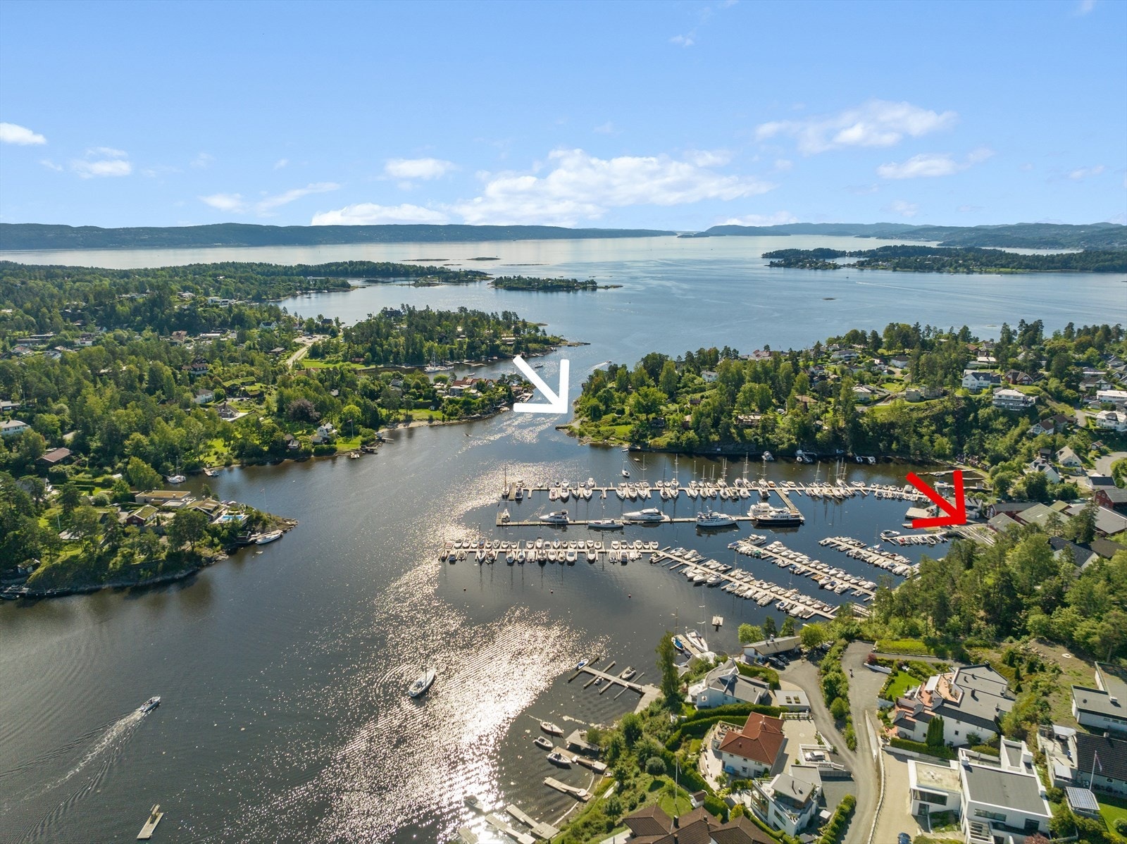 Nydelig badeplass like ved (hvit pil). Mulighet for båtplass på Holmen Yachtverft (rød pil). Galleribilde